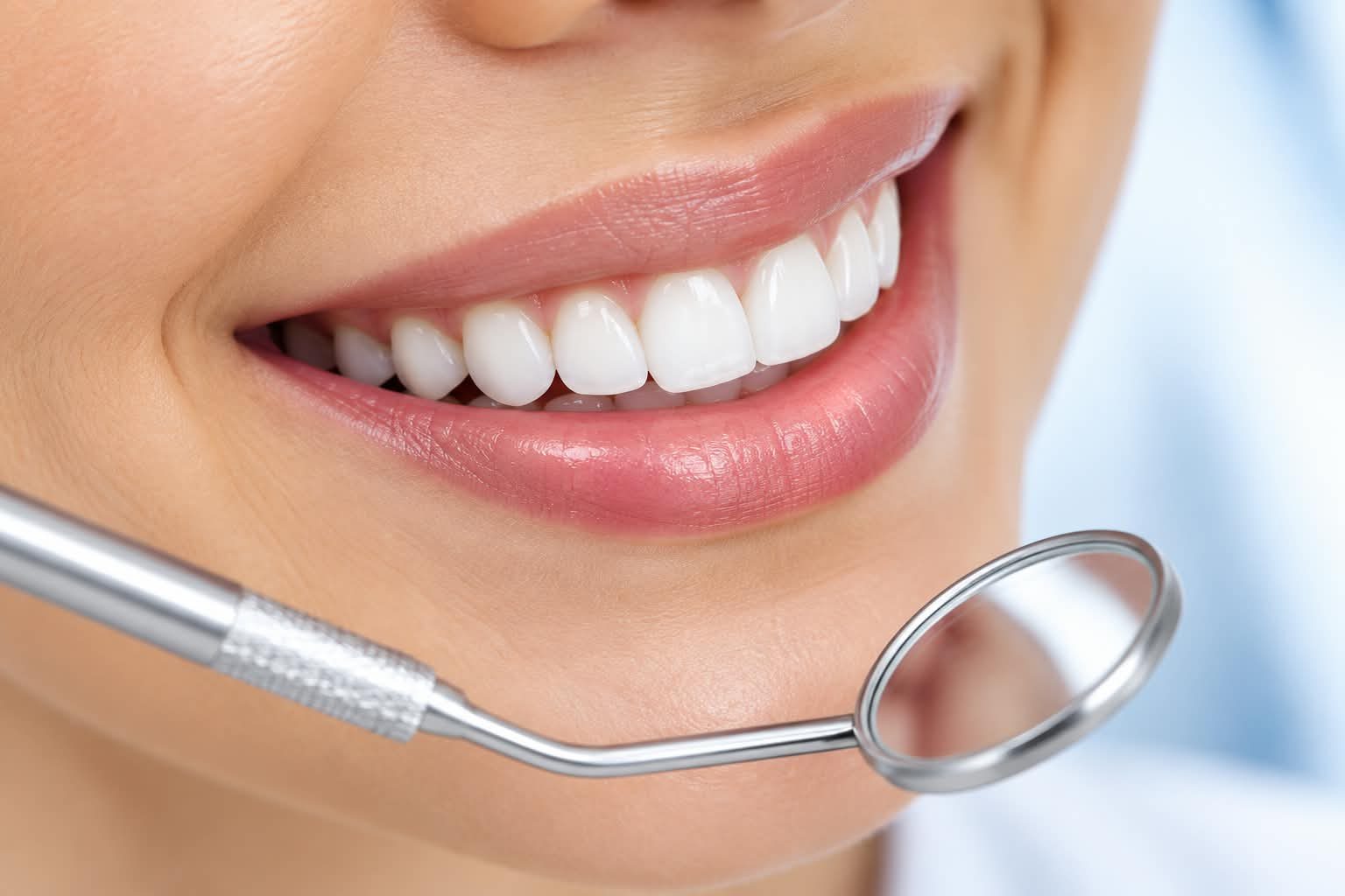 Close-up of a smile with a dental mirror